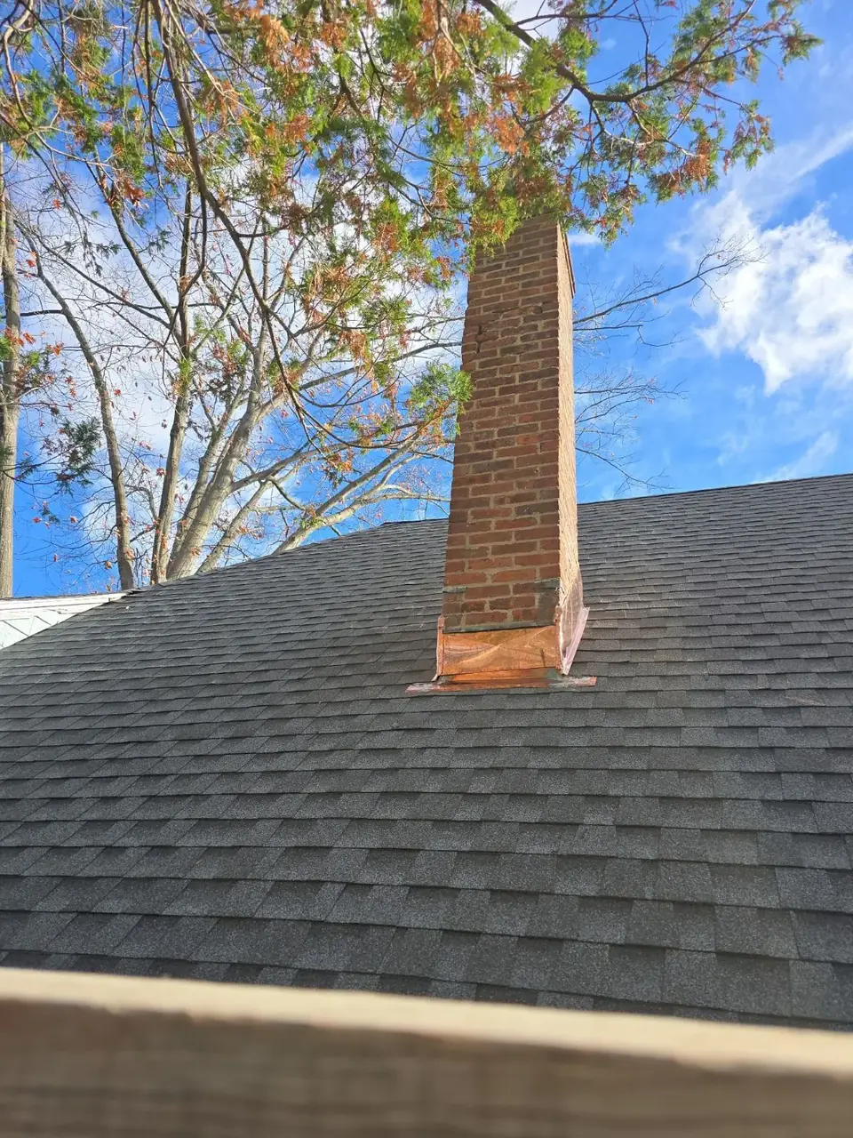 Finished brick chimney above a residential roof