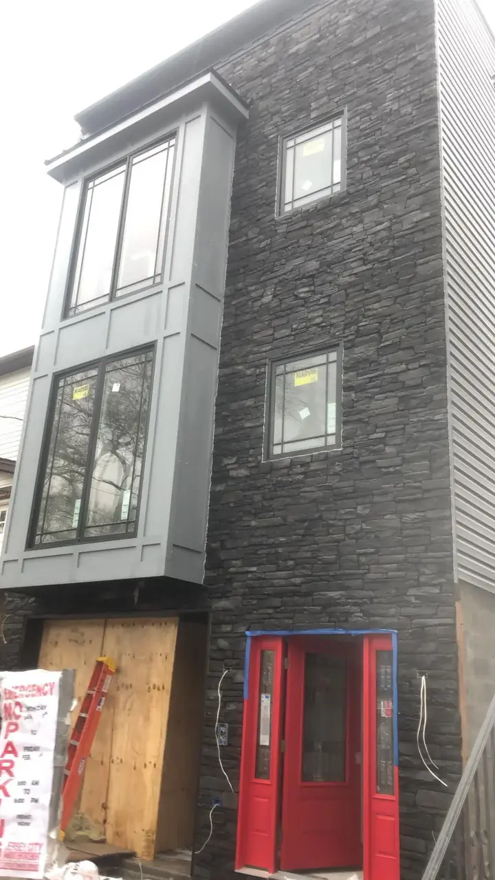 Modern dark stacked-stone facade on a multi-story residence